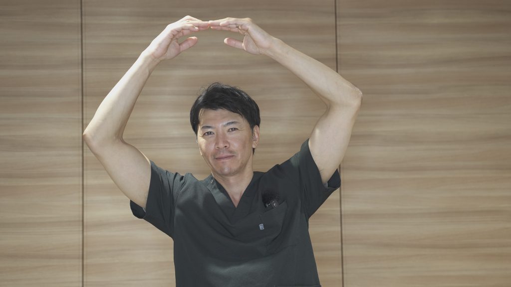 頭の上で丸をつくる竹江総院長