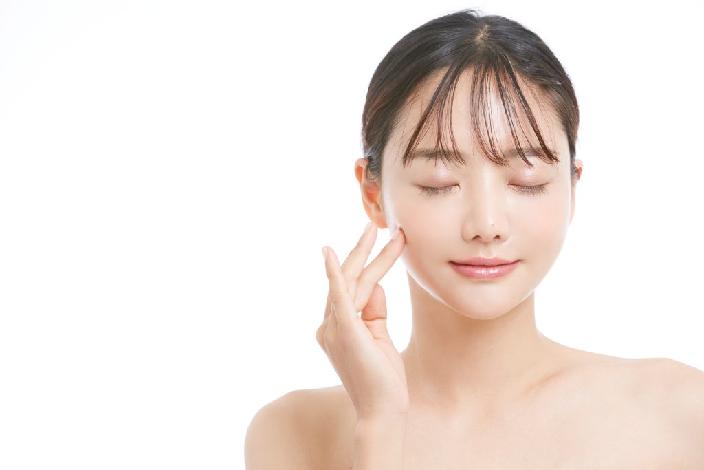 頬を触る女性写真